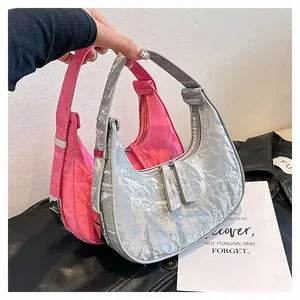 Detail van roze halve maan tas met geplooide textuur en metalen verstelbare gesp