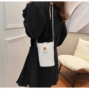 Détail du petit sac bandoulière en cuir blanc avec chaîne dorée et bille de réglage