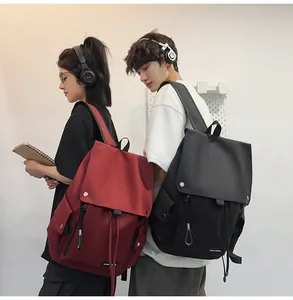 Detail of red and black drawstring backpacks featuring flap closures and durable nylon texture