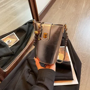 Petit sac seau argenté métallisé avec boucle dorée et bandoulière en chaîne