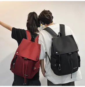 Rear view of models wearing large capacity nylon backpacks in dark red and black