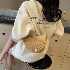 Straw bucket bag with pearl buckle shown on model for a trendy summer vacation look