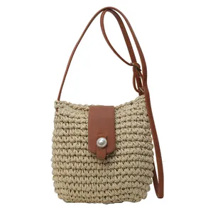 Handgeweven strooien emmer tas met bruine lederen flap en grote parel decoratie