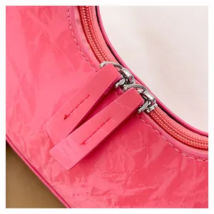 Close-up van felroze glanzend laklederen handtas met dubbele ritssluiting details