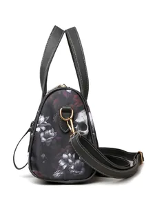 Side view of luxury skull and floral print crossbody bag with golden hardware details