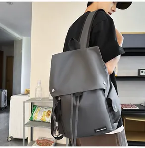 Detail view of dark grey backpack with drawstring closure and magnetic flap for travel