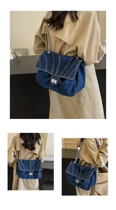 Gros plan détaillé du sac en denim bleu avec fermoir argenté et bandoulière chaîne