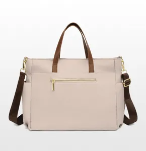 Rear view of beige 15.6-inch laptop bag with brown handles and gold zipper pocket