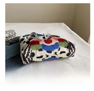 Detail showing the wear-resistant base and colorful cow print of the canvas tote bag
