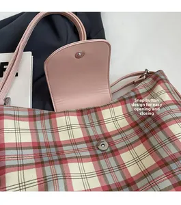 Detailansicht der rosa Lederkante und des Magnetverschlusses an der karierten Tasche