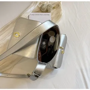 Interne vakken van de zilveren crossbodytas met opbergruimte en gouden draaisluiting