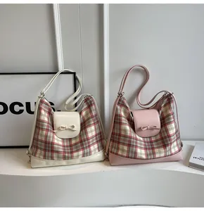 Details karierter Einkaufstaschen mit Lederschleifen in Beige und Rosa Tönen