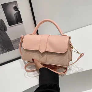 Detail van roze leer en beige canvas stiksels op een stijlvolle crossbody tas