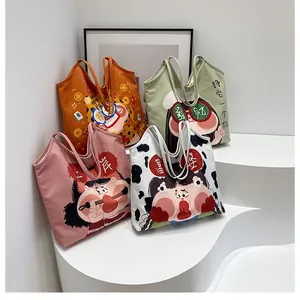 Detail shot of four colorful canvas tote bags with cute cartoon illustrations on white steps