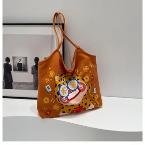 Detail of orange canvas tote bag featuring lucky leopard print and wide shoulder strap