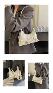 Detail van de beige Hobo-tas met decoratieve zilveren gespen en Y2K-bikerstijl riempjes