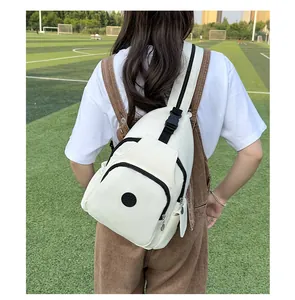Detail of white nylon chest bag featuring a round logo and black adjustable buckle strap