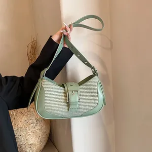 Detail of avocado green shoulder bag featuring woven texture and silver metal buckle