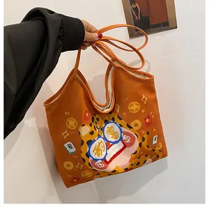 Detail of orange canvas tote bag featuring traditional lion dance and mahjong motifs