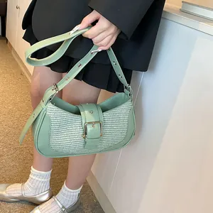 Detail of light green woven patchwork underarm bag with vintage metal buckle strap