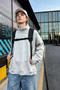 Street style εξωτερικού χώρου με γκρι μπλούζα με ψηλό λαιμό και μαύρο σακίδιο πλάτης