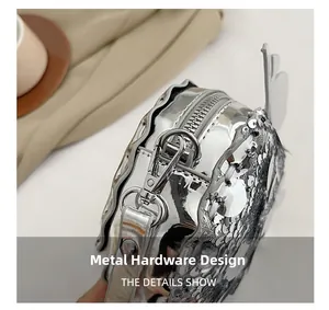 Dettaglio della borsa di paillettes argento con hardware metallico e decoro ad ala