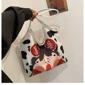 Detail of cute cow print canvas tote bag featuring a cartoon girl with Chinese character