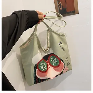 Detail of light green canvas tote bag with cartoon design and Chinese calligraphy