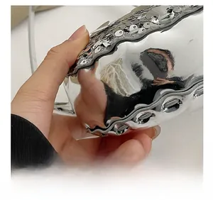 Dettaglio borsa con paillettes argento effetto specchio e bordo ondulato