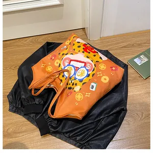 Detail of orange canvas tote bag featuring lucky cartoon cat print and dollar glasses