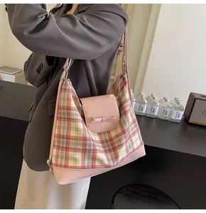Detail der rosa karierten Tragetasche mit Lederschleife und verstellbarem Riemen am Modell