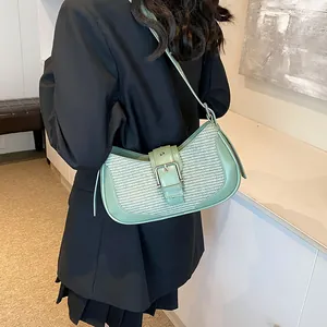 Detail shot of mint green woven shoulder bag with leather trim and silver metal buckle