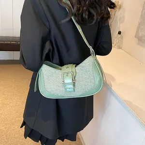 Detailed texture of mint green woven fabric and leather trim on a stylish baguette bag