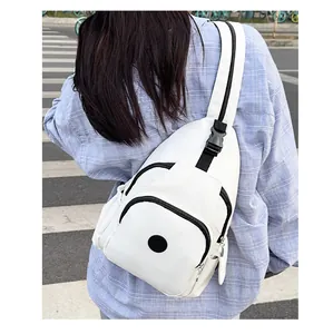 Outdoor shot of white nylon chest bag with multiple zippers and wide black strap