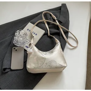 Detail of elegant Chinese style silk bag with floral embroidery on grey suit background