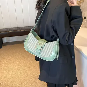 Detail of mint green leather underarm bag with woven texture and large metal buckle