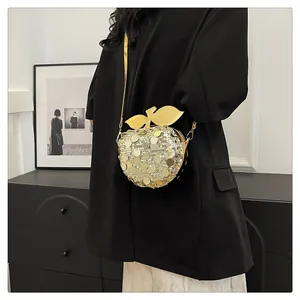 Dettaglio borsa a forma di mela glitterata con paillettes dorate e foglia metallica