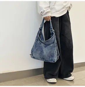 Detail van verstelbare metalen gesp en gewassen denim textuur op een blauwe hobo tas