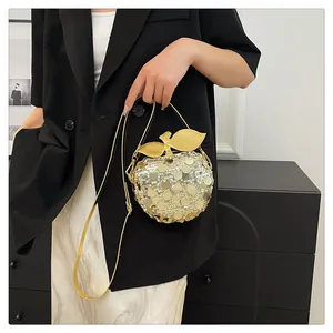 Dettaglio borsa a tracolla a forma di mela con paillettes dorate e cinturino in pelle