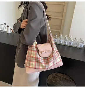 Detailaufnahme einer rosa karierten Tragetasche mit Schleife, getragen von einem Model