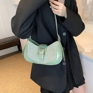 Detail of light green half-moon underarm bag with leather buckle and woven texture