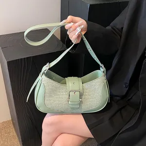 Close-up of mint green underarm bag featuring woven texture and silver buckle