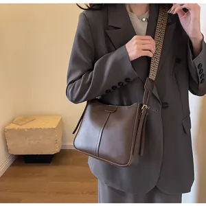 Detail van vintage bruine lederen tas met stijlvolle brede geometrische jacquard riem