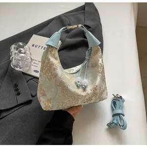Detail of light blue Chinese embroidery handbag with floral patterns on a gray blazer