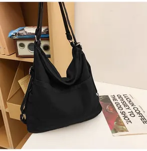 Detail van de zwarte canvas shopper met zijvak en stevige metalen gespen voor dames