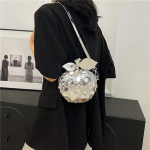 Elegante borsa a tracolla con paillettes argentate a forma di mela indossata da modella