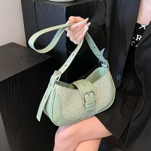 Detail of light green leather and woven baguette bag with adjustable eyelet strap
