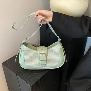 Detail of light green leather and beige woven fabric underarm bag with silver buckle