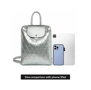 Size comparison of silver quilted backpack with a tablet and phone on white background