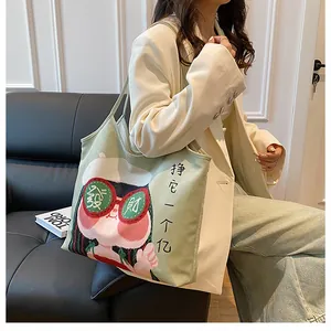 Detail of light green canvas tote bag with creative cartoon pig illustration and handles